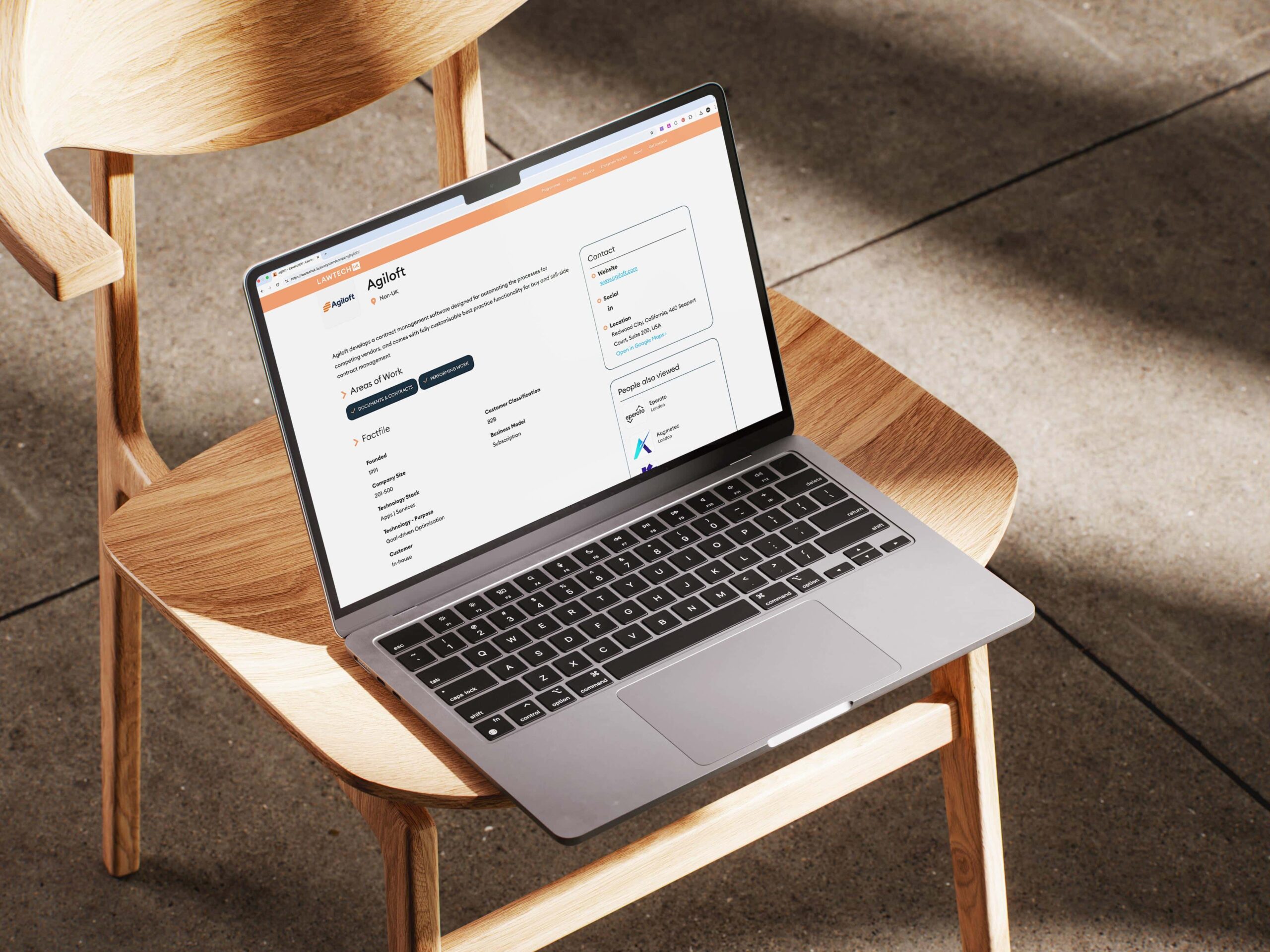 LawTech UK company profile for Agiloft on a laptop screen, displaying detailed brand information, areas of work, and contact details for legal contract management software.