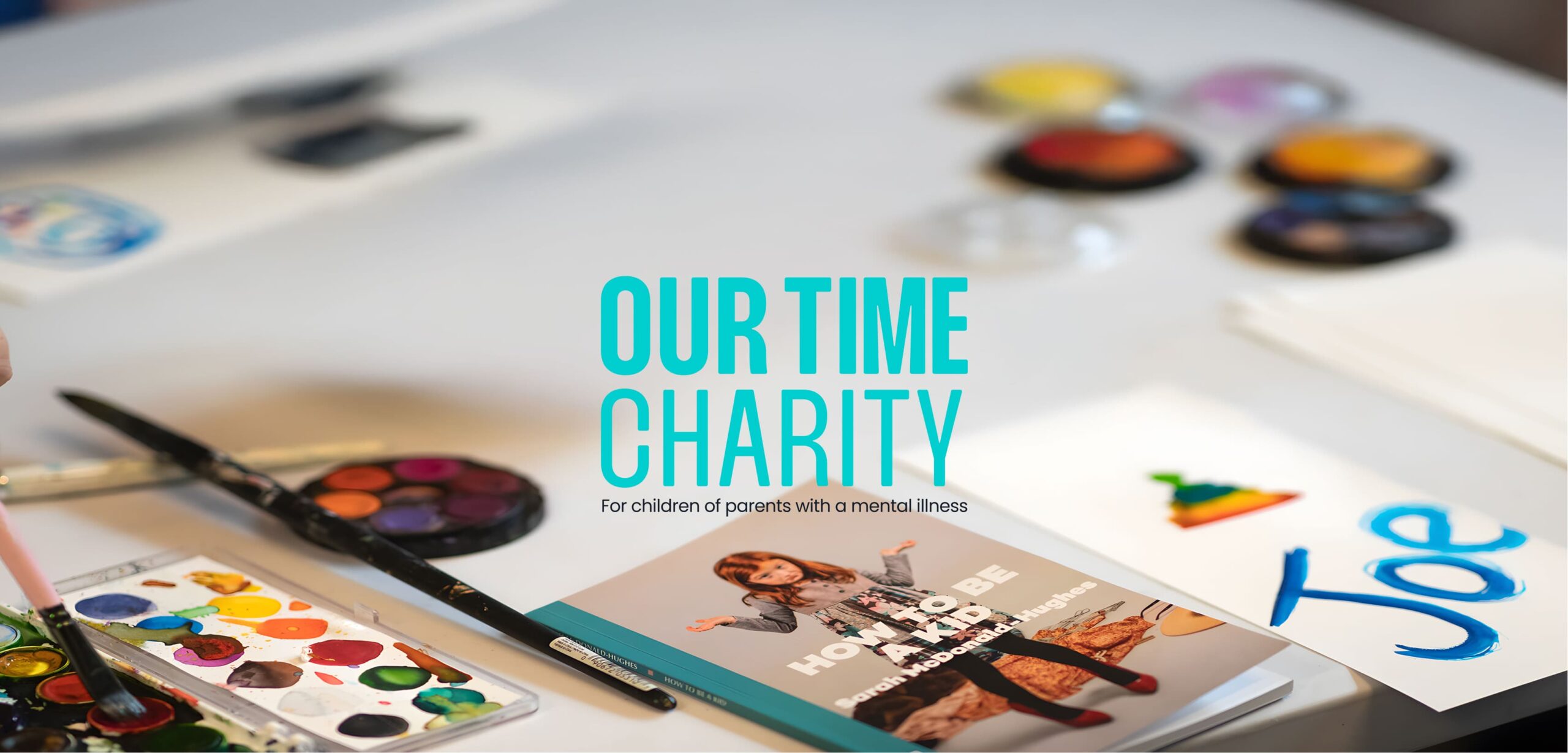 Our Time Charity logo displayed on creative workspace designed through CRM-based brand strategy and website development