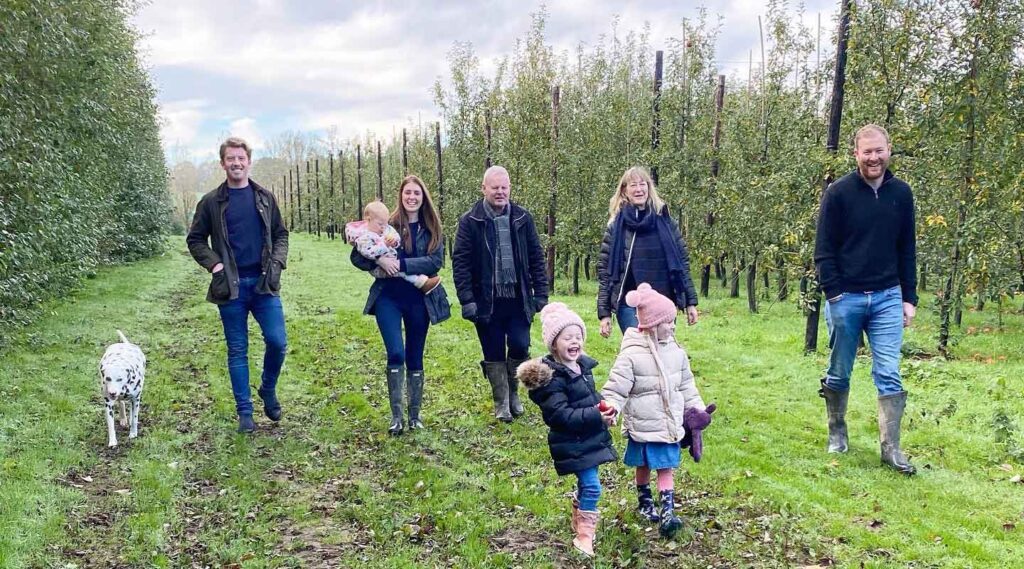 People walking through a green countryside pub garden in Kent, reflecting the rural setting and landscape associated with Chegworth Valley farm-pressed juices.